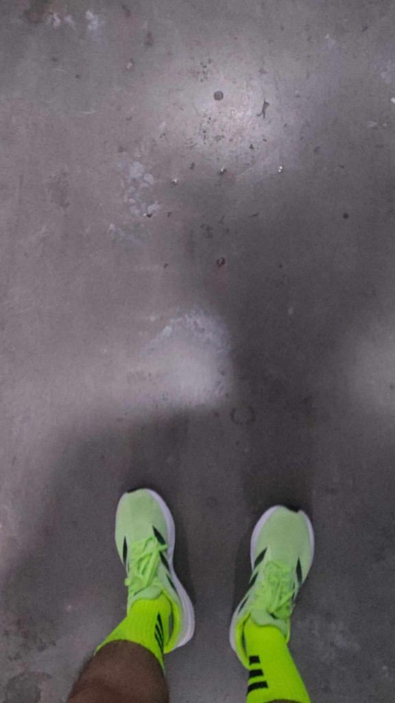 Nico's neon green sneakers on concrete — casual, personal style